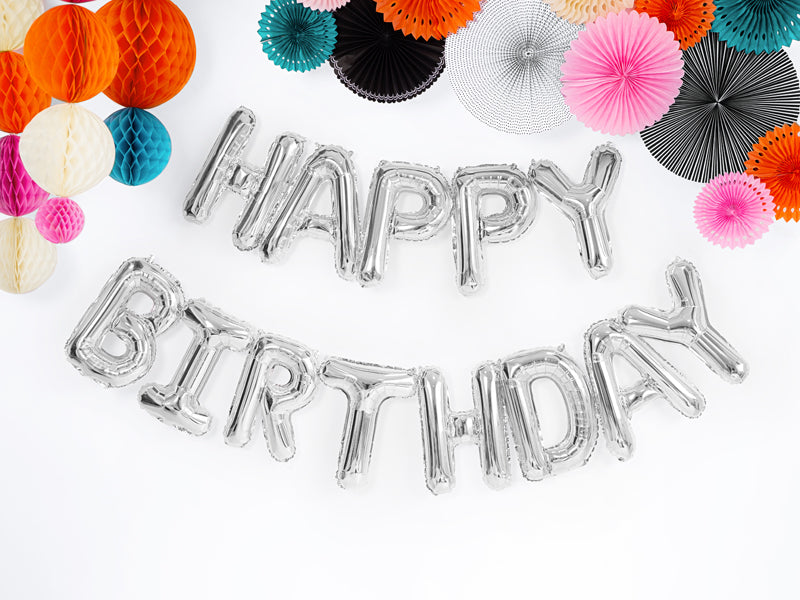 Silberner HAPPY BIRTHDAY Folienballon als festliche Geburtstagsdekoration mit liebevoll dekorierter Geburtstagsüberraschung
